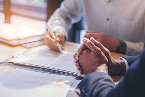 How to Obtain a Florida Financially Responsible Officer (Fro) Bond - Businessman Reading Documents at Meeting, Business Partner Considering Contract Terms Before Signing Checking Lega